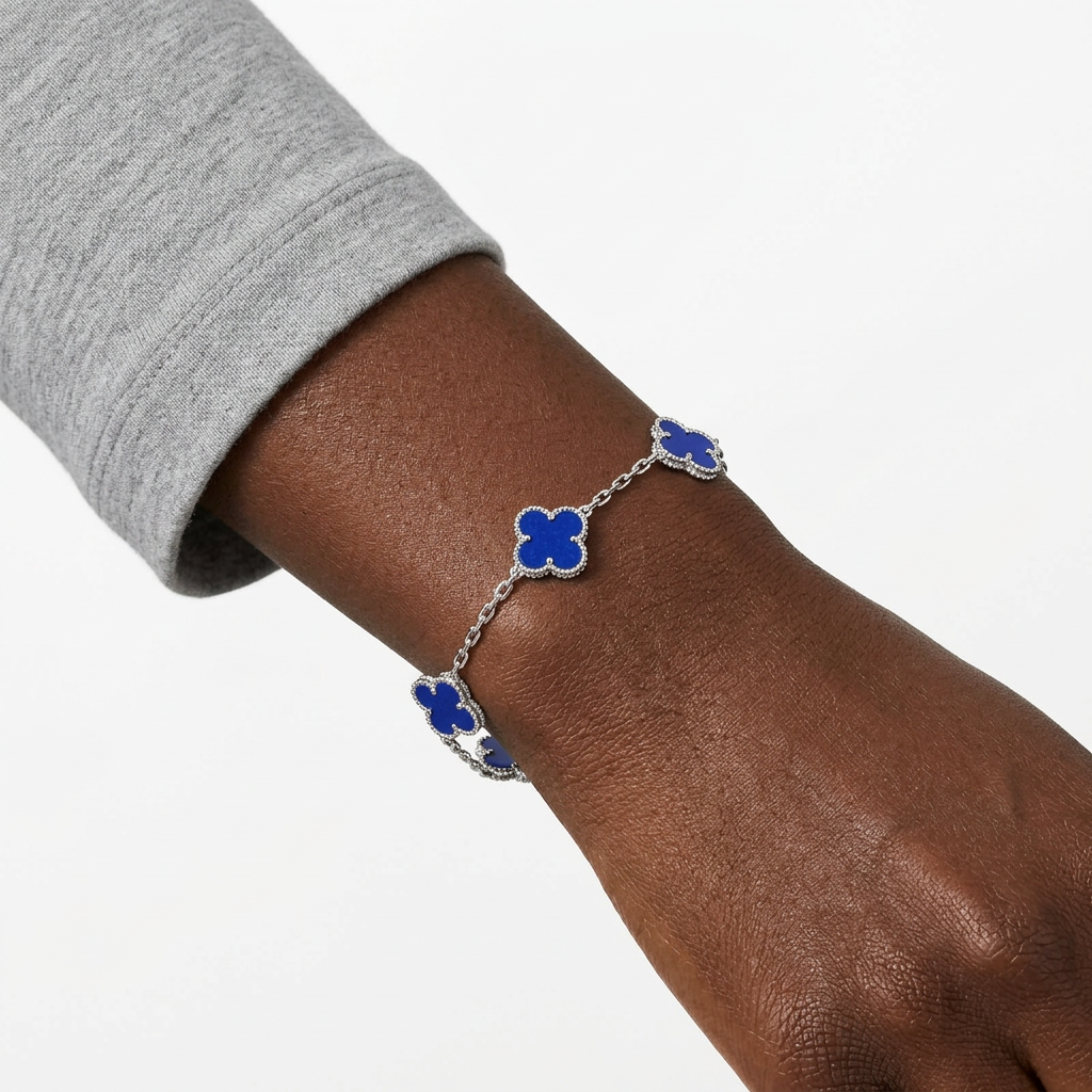 Silver-tone all-blue clover bracelet on a Black adult wrist