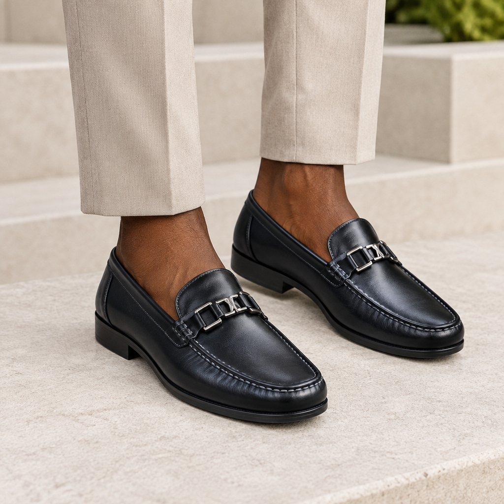 Black model wearing black men's loafers with polished metal detail