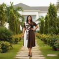 Nigerian female model wearing dark brown and white abstract print pleated midi gown in upscale garden setting