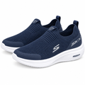 Pair of navy knit slip-on sneakers with sculpted white soles on white