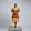 Nigerian female model wearing black base African print bubu top with gold crochet lace yoke and hem