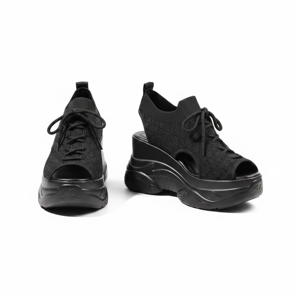 Pair of all-black peep-toe knit high wedge sneakers with tall platform wedge sole on white background