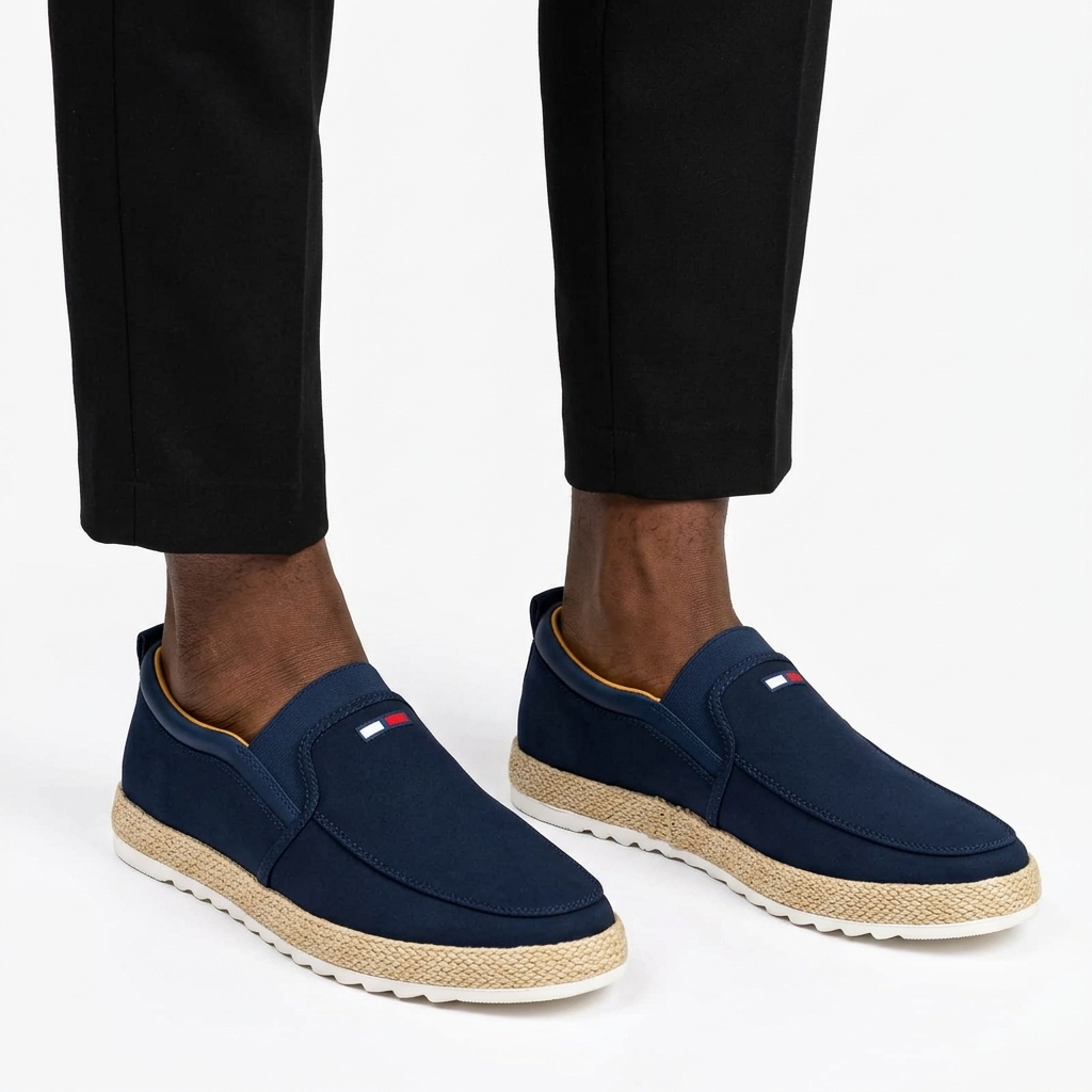 Navy woven-trim slip-on sneakers properly worn on both feet