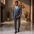 Young Nigerian male model wearing charcoal grey 3-piece suit with teal tie and pocket square