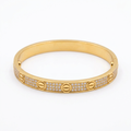 Gold-tone stone-set screw-motif bracelet on white