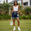 Nigerian female model wearing navy blue drawstring cuffed denim shorts in garden setting