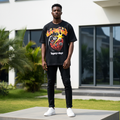 Nigerian male model wearing men's black flame and grenade graphic short-sleeve tee full body streetwear editorial shot