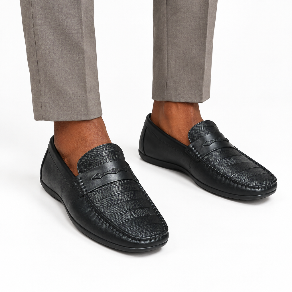 Both black loafers worn ankle-down on plain white