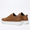 Pair of tan textured white-sole sneakers on a white background