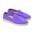 A pair of purple suede loafers with light cream soles, centered on white