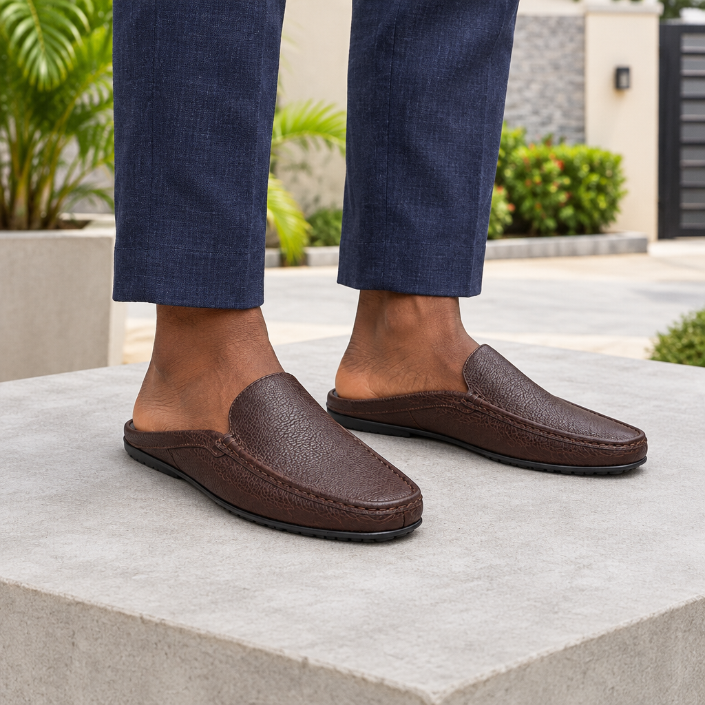 Man wearing brown backless mule slippers with navy linen trousers