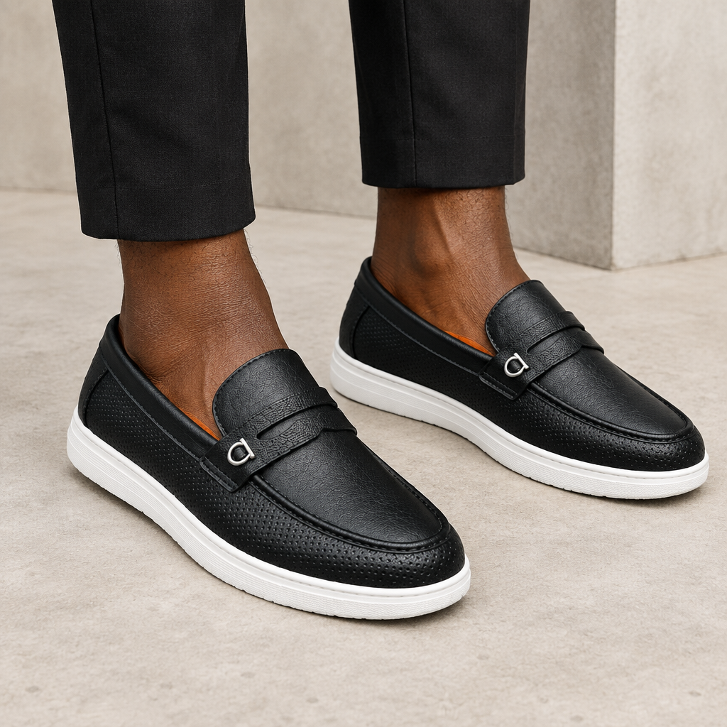 Black perforated ring loafers worn on both feet