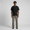 Nigerian man wearing black plaid-pocket top and matching check trousers