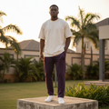 Nigerian male model wearing deep purple jogger pants streetwear outdoor setting