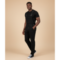 Man wearing solid black denim bib overalls over a black t-shirt