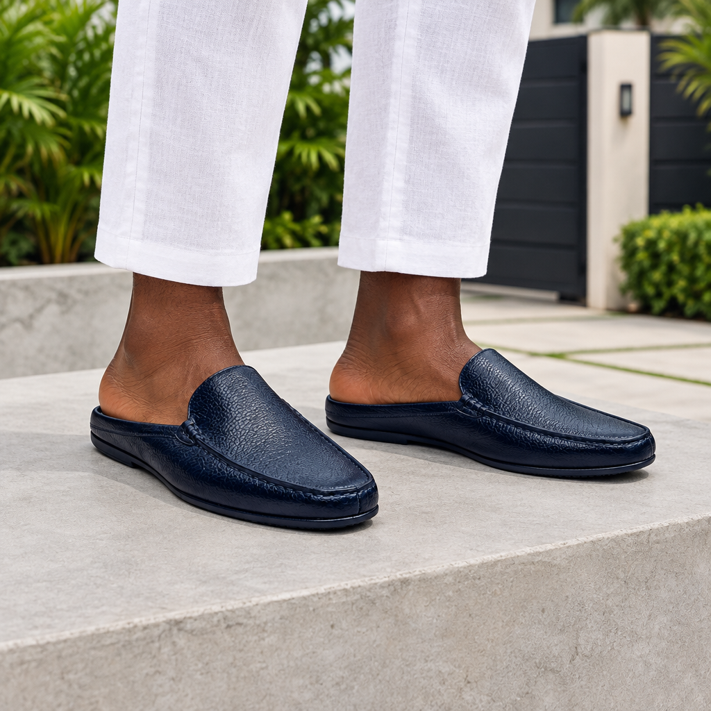 Man wearing navy blue backless mule slippers with white linen trousers