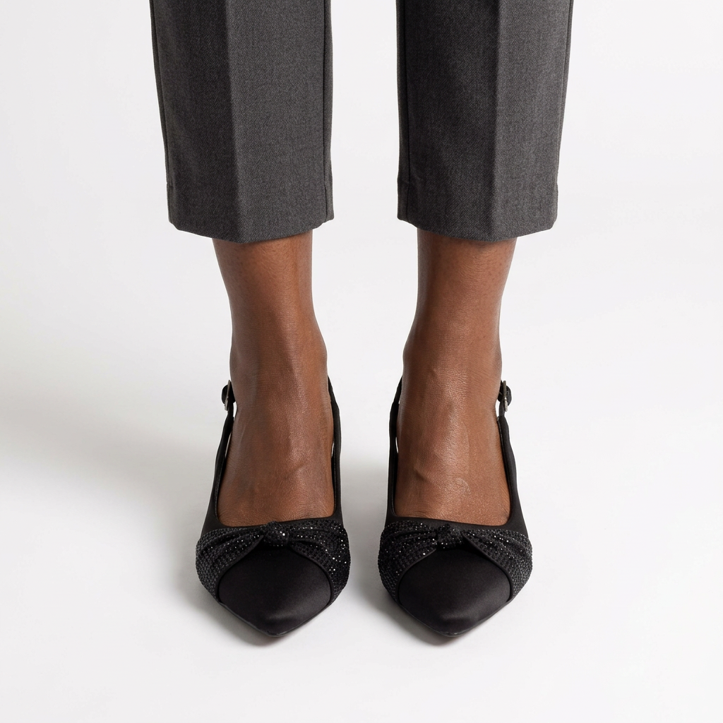Woman wearing black embellished slingbacks with both feet visible