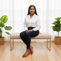 Nigerian female model seated wearing tan croc-embossed patent ballet flats with square silver buckle detail