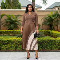 Nigerian female model wearing camel and cream paisley pleated midi wrap gown in upscale garden setting