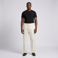 Full-body male model wearing cream drawstring trousers