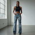 Nigerian female model wearing vintage washed blue chain and bow graphic flare jeans front view