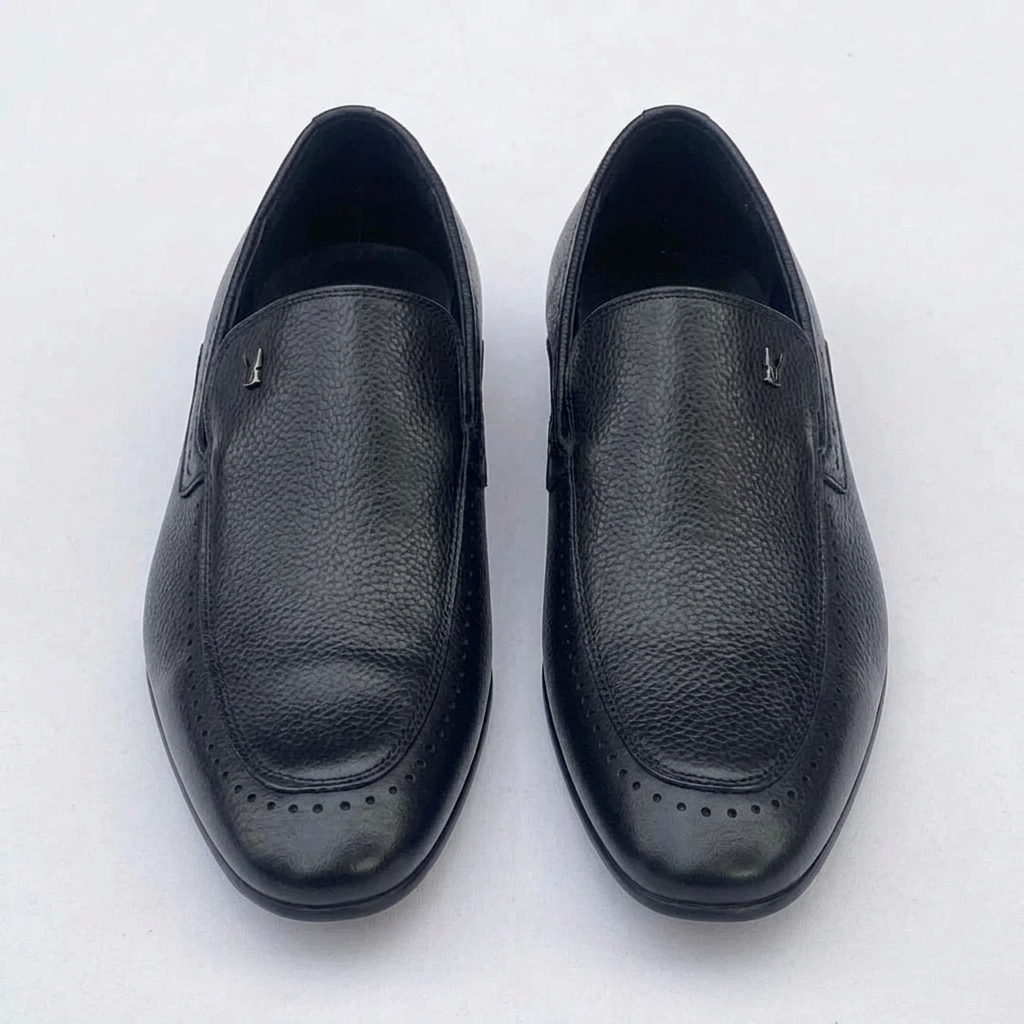Straight-on black textured loafers with perforated toe borders