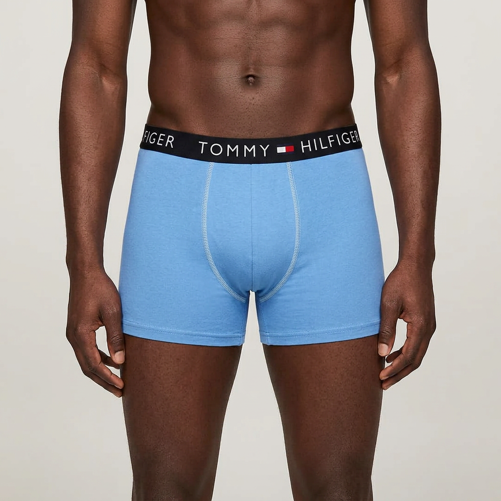 Male model wearing only medium blue boxer briefs in one studio frame