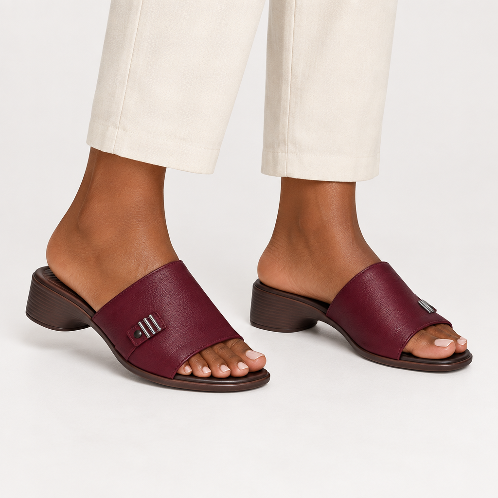 Black adult woman wearing maroon open-toe block heel slide sandals, leg-focused view showing both shoes