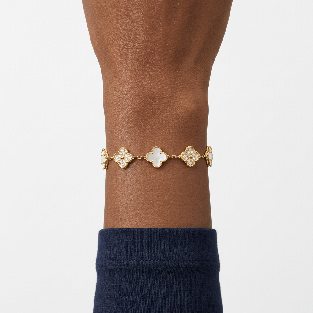 Gold-tone clover charm bracelet on a Black adult wrist