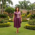 Nigerian female model wearing mauve and deep plum two-tone pleated midi gown in upscale garden setting