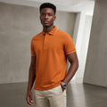 Young Nigerian male model wearing burnt orange tipped polo shirt
