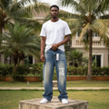 Nigerian male model full body wearing men's wide-leg blue graphic denim jeans