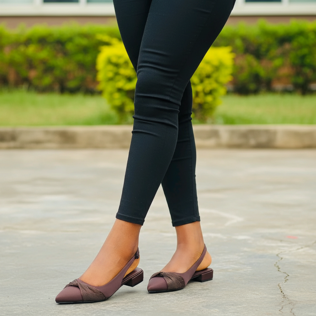 Plus-size Nigerian female model wearing brown crystal bow slingback block heel sandal — leg focus
