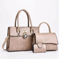 Pale coffee-brown three-piece set with two top-handle handbags and snap wallet on white background