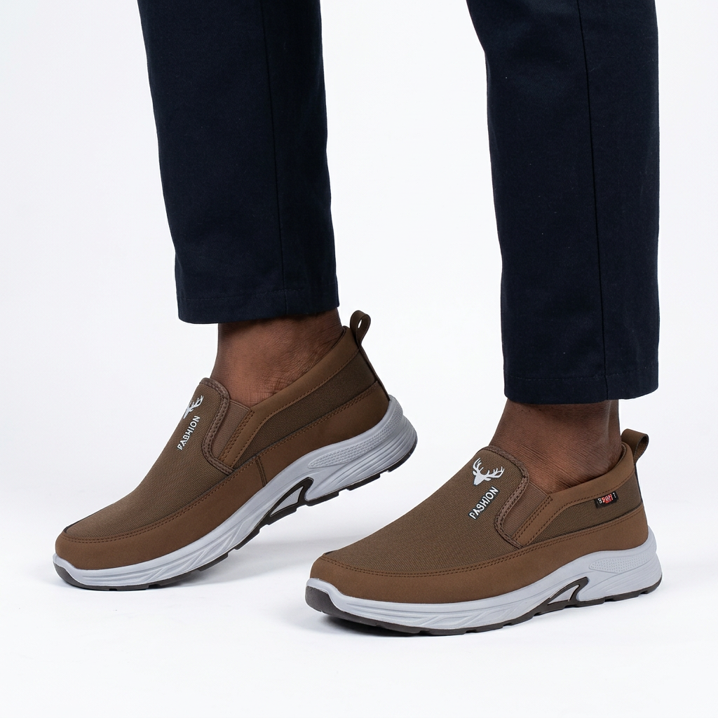 Brown slip-on shoes worn on both feet by a Black male model on white