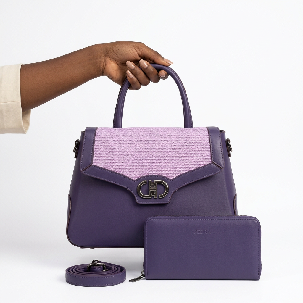 Black adult woman’s hand holding a purple and lilac handbag set on white