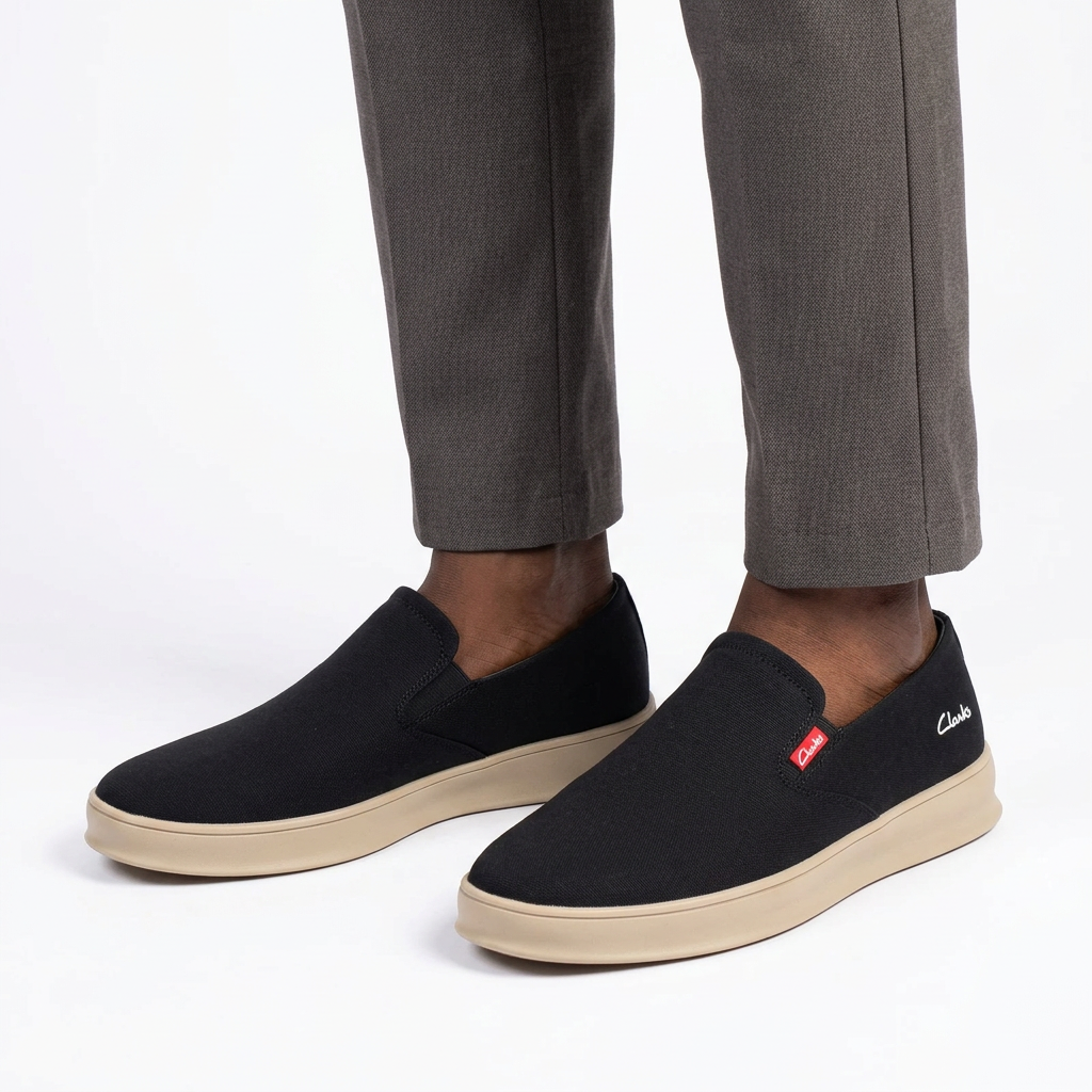Both black slip-on sneakers worn by a Black male model on white