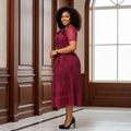 Nigerian woman wearing burgundy lace floral peplum top and pleated midi skirt set