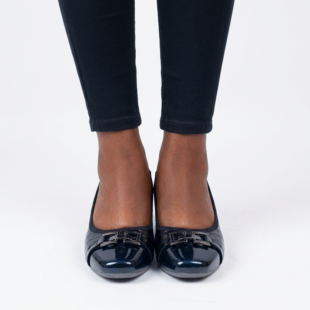 Adult woman wearing black buckle-detail wedge shoes with feet together