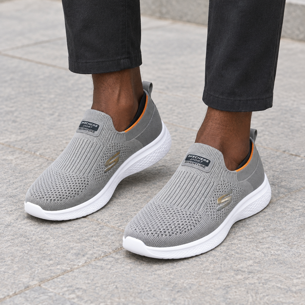 Grey knit slip-on sneakers worn on both feet