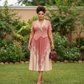 Nigerian female model wearing dusty rose ombre pleated midi gown with lace collar in upscale garden setting