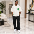 Man wearing cream oversized green gothic letter tee