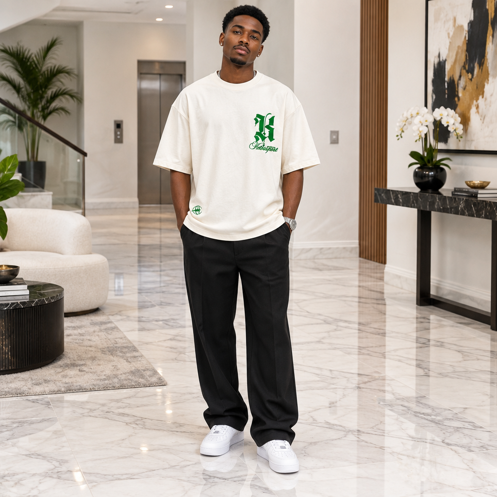 Man wearing cream oversized green gothic letter tee
