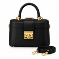 Black structured handbag with gold-tone clasp and matching strap on white