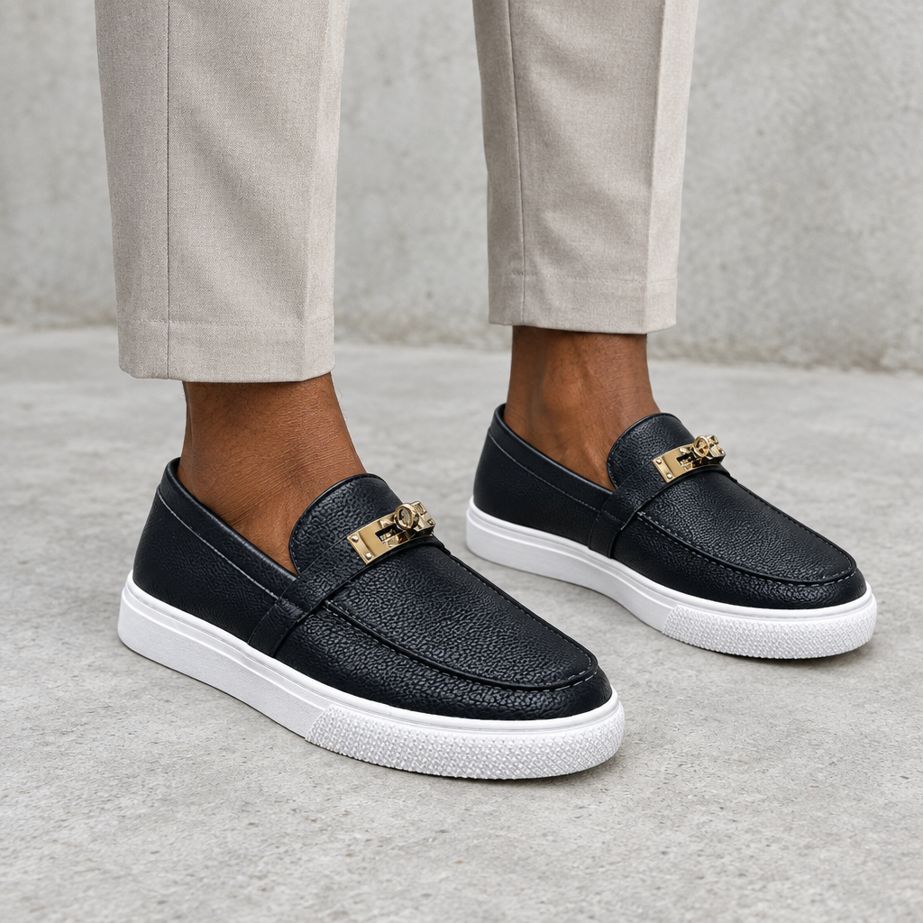 Black pebbled loafers with white soles, worn on both feet