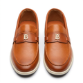 Pair of cognac slip-on loafers with gold-tone details and pale sole edges