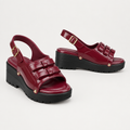 Burgundy multi-strap platform sandals with metallic studs and black soles