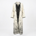 Cream and black ornate-panel abaya on an invisible mannequin against white