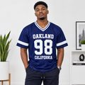 Young Black Nigerian man wearing Oakland 98 California navy mesh varsity jersey