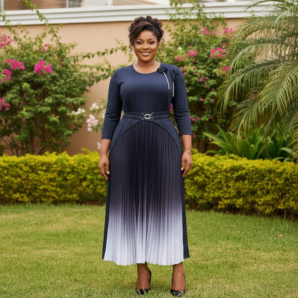 Nigerian female model wearing navy to white ombre pleated midi gown with flower corsage in upscale garden setting